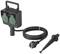 Black electric outdoor socket with two green covers, long cable, and ground stake for garden installation.