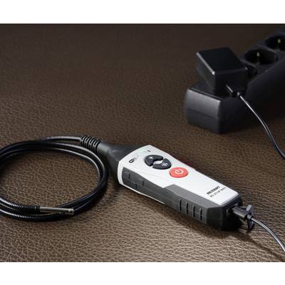 Digital temperature measuring device with probe cable and display next to a multi-socket extension lead, showing electrical connections and control panel.
