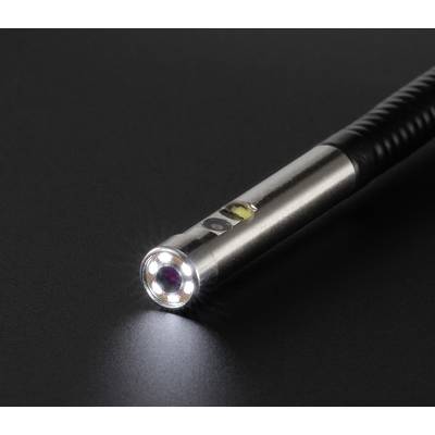 Close-up of a small torch on a dark background. The torch is emitting bright light from the lens at its tip.
