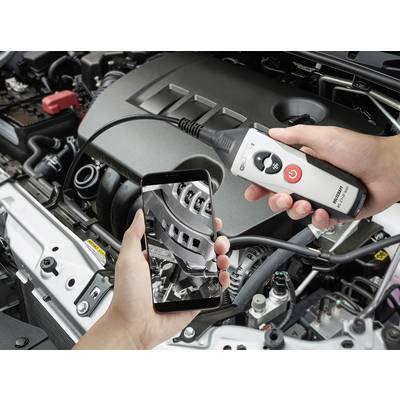 A person is examining a car engine with a smartphone and endoscope. The display shows a close-up image of the internal engine components.