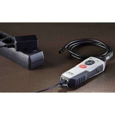 A multi-socket extension lead and an electric tool with a red switch are lying on a brown surface.