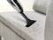 A hoover is used to remove hair and dirt from a grey fabric sofa.