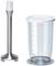 A metal hand blender attachment stands next to a transparent measuring jug with a white lid. The jug has a scale up to 700 ml.