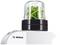 A food processor with an attachment, filled with green herbs. The Bosch logo is visible on the appliance.
