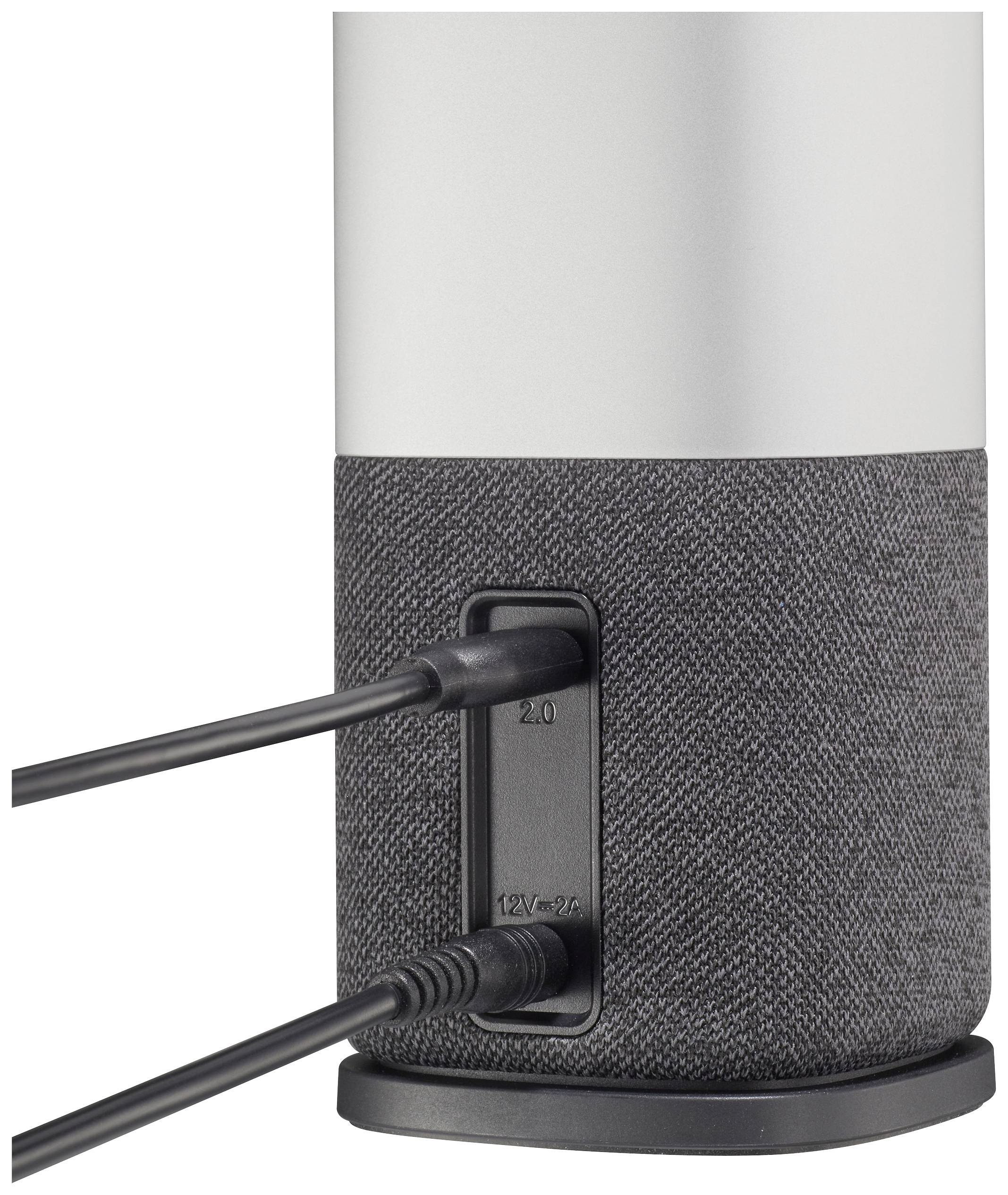 A speaker with a grey-black fabric detail, showing the connections on the back with two plugged-in cables.