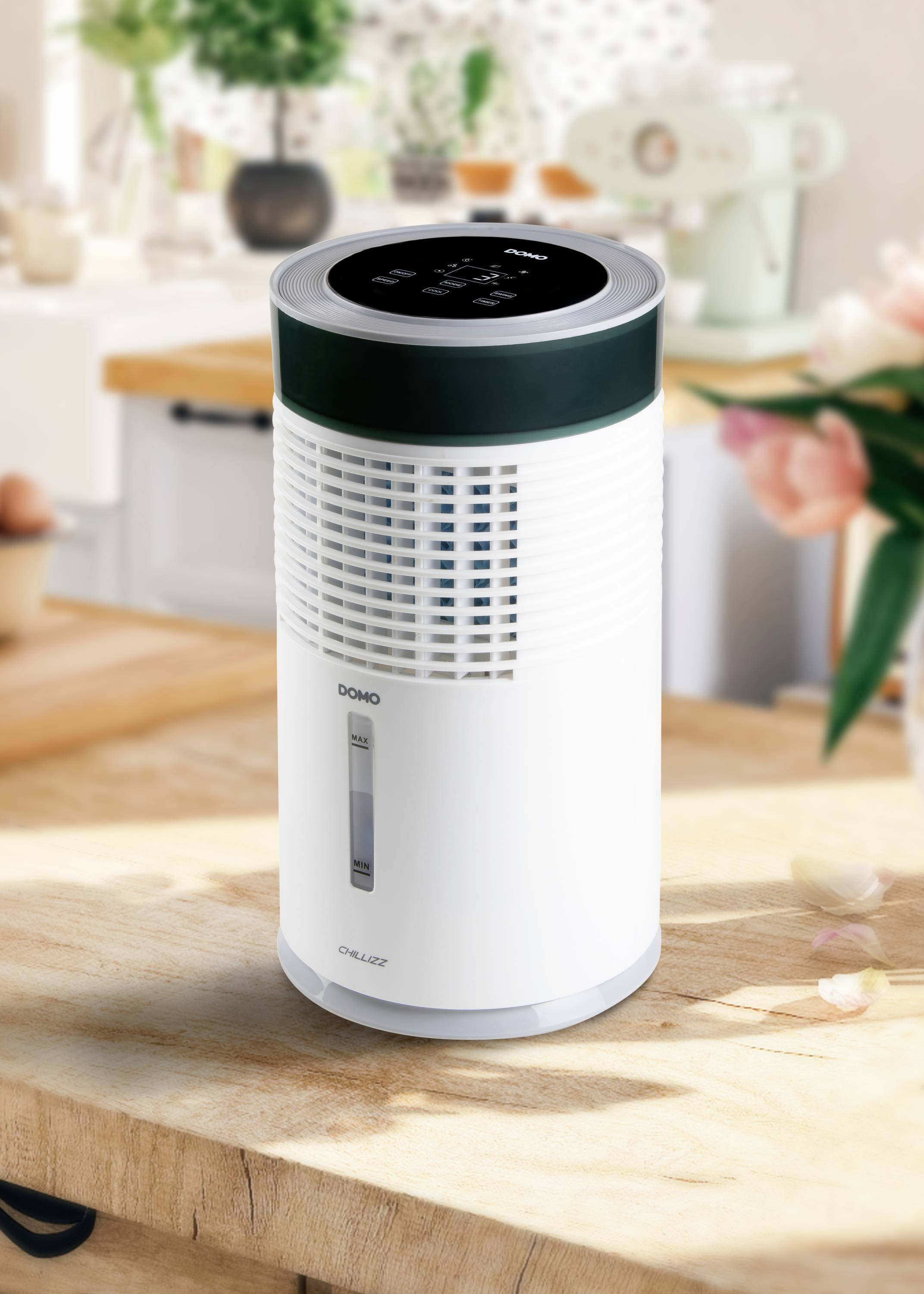 A dehumidifier on a kitchen table, surrounded by flowers and kitchen utensils, with a digital display on top.