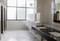A modern, clean lavatory with toilets, urinals and washbasins. Large windows allow plenty of light to enter.
