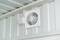 Ventilation fan mounted on a ceiling for aerating rooms or buildings. White square cover surrounding the fan.