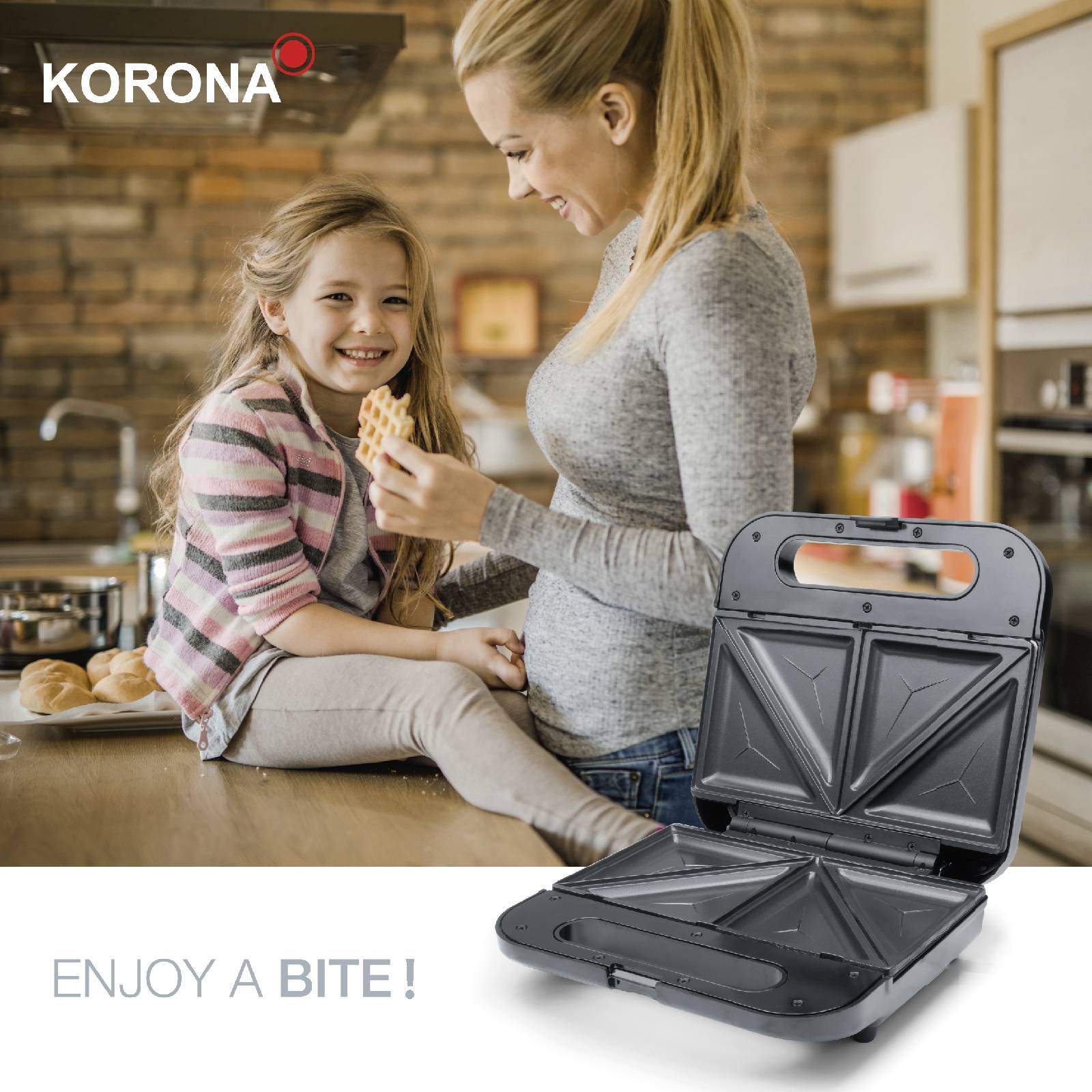 Mother and daughter in the kitchen. Mother holding a sandwich, whilst the daughter sits on the worktop. Text reads 'Enjoy a Bite'.
