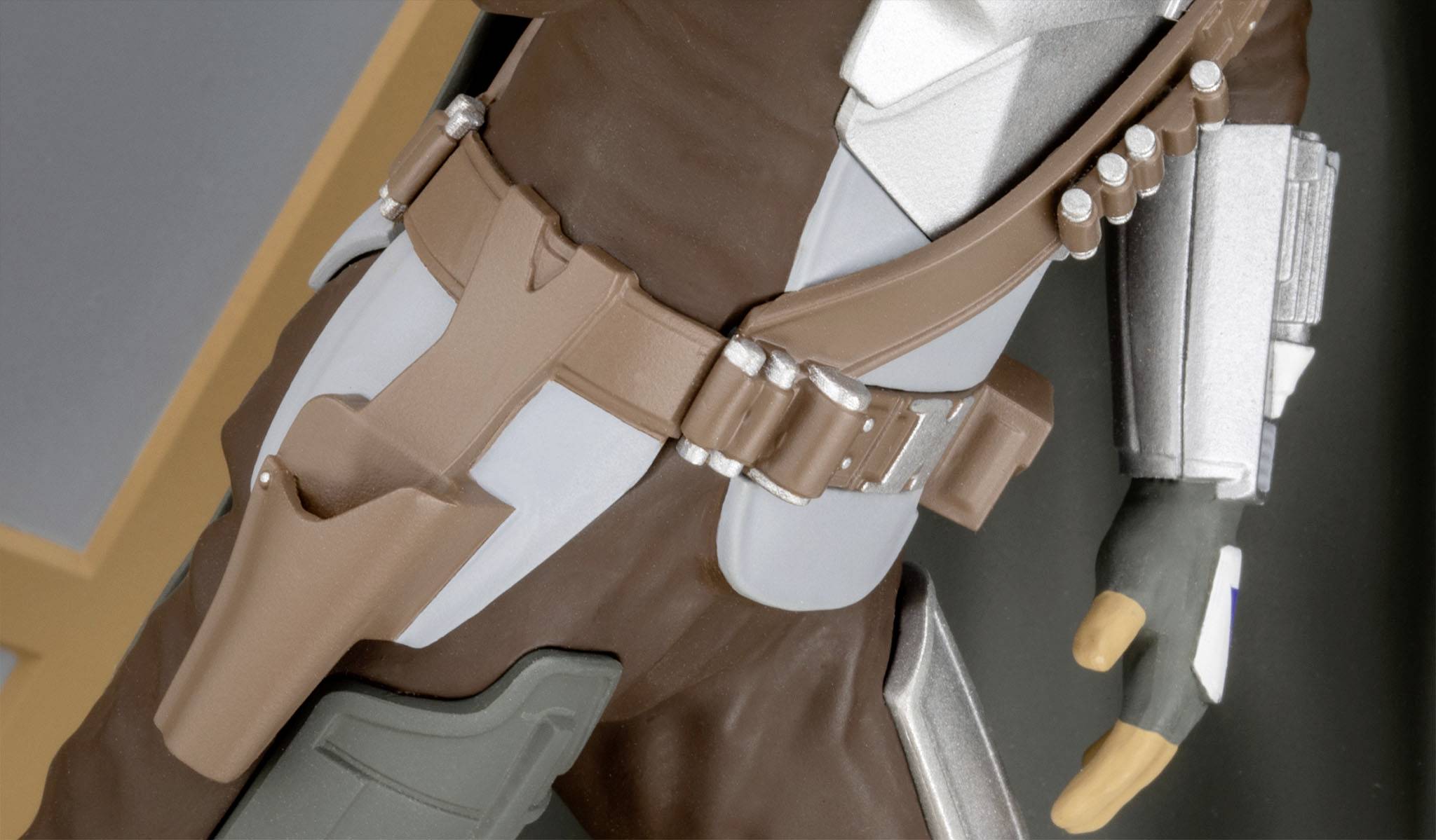 A close-up of a costume with brown and silver elements, including details such as a belt and holster.