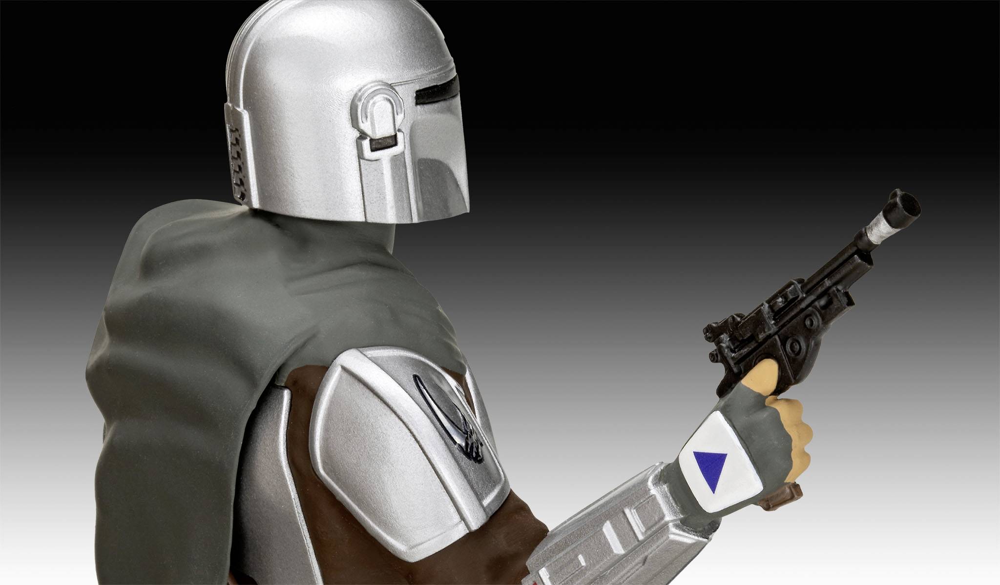 A person in silver armour holds a pistol. They are wearing a grey cape.