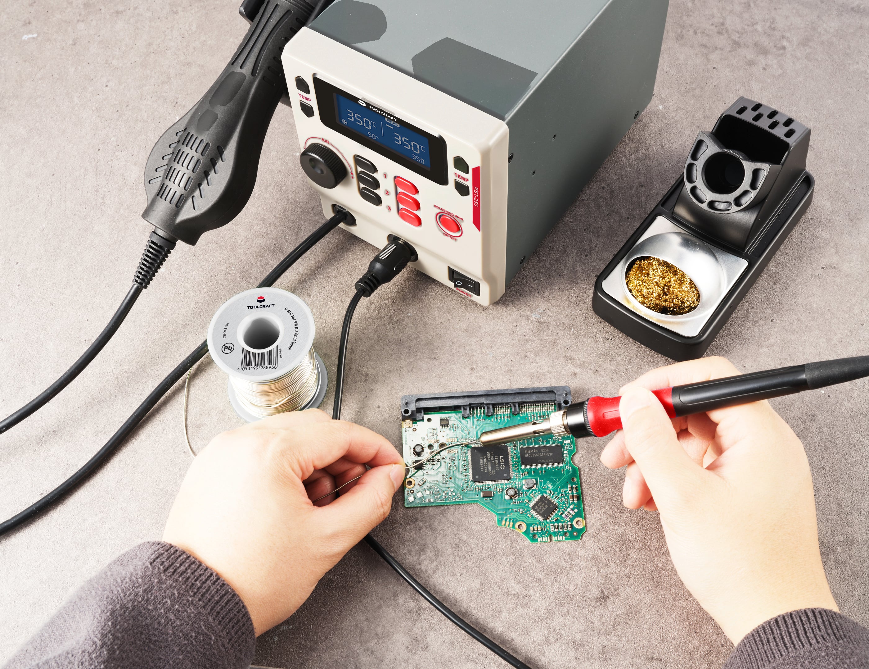A person is soldering with a soldering iron on a green circuit board. Solder wire and a soldering station are lying on the table.