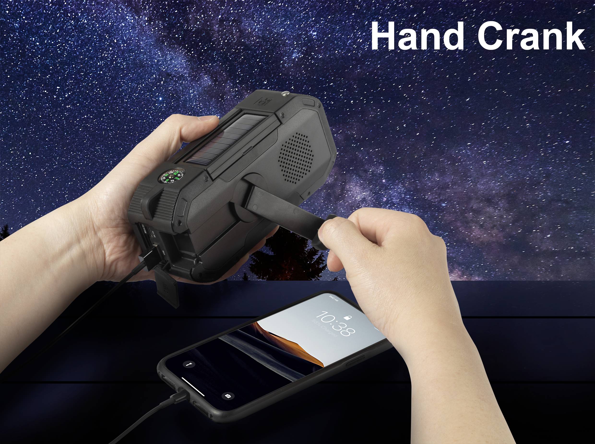 A person is using a crank on a black, portable device to charge a smartphone. The night sky is visible in the background.