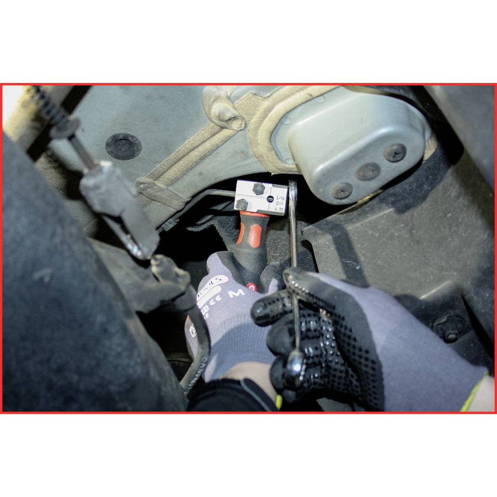 A person pulls a lever in a vehicle with one hand. They are wearing gloves and are carrying out maintenance or repair work.