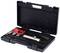 Black tool case with open lid. Contains a silver tool, a red attachment, and two metal blocks.