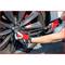 A person is tightening the wheel nuts of a car tyre using a torque wrench. The person is wearing red gloves.