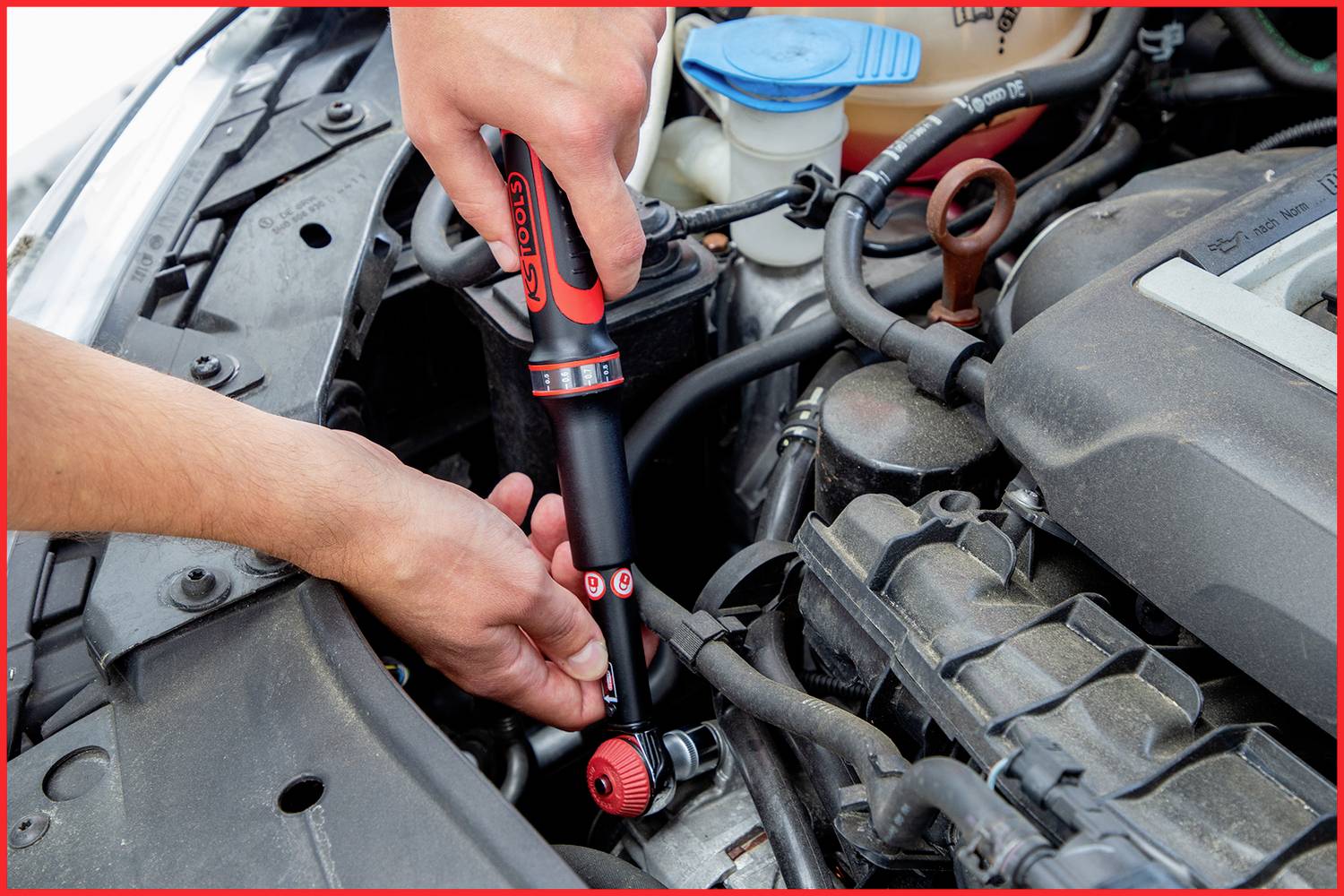 A person is checking the car's engine with a torque wrench. The engine compartment is partially visible.