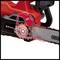 'Electric chainsaw focusing on oil refilling and safety mechanism. The arrow indicates the correct position for topping up the oil.'