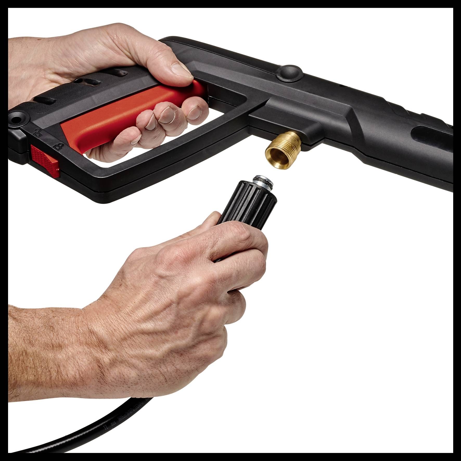 A hand is holding a black pressure washer nozzle, while the other hand is screwing a hose connection onto the nozzle.