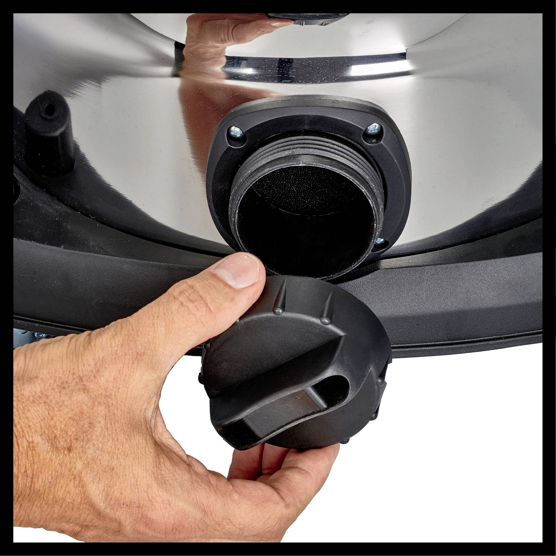 A hand closes the lid on a metal opening.