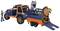 A toy off-road vehicle with a trailer transporting two dinosaur figures. A human figure stands beside it.