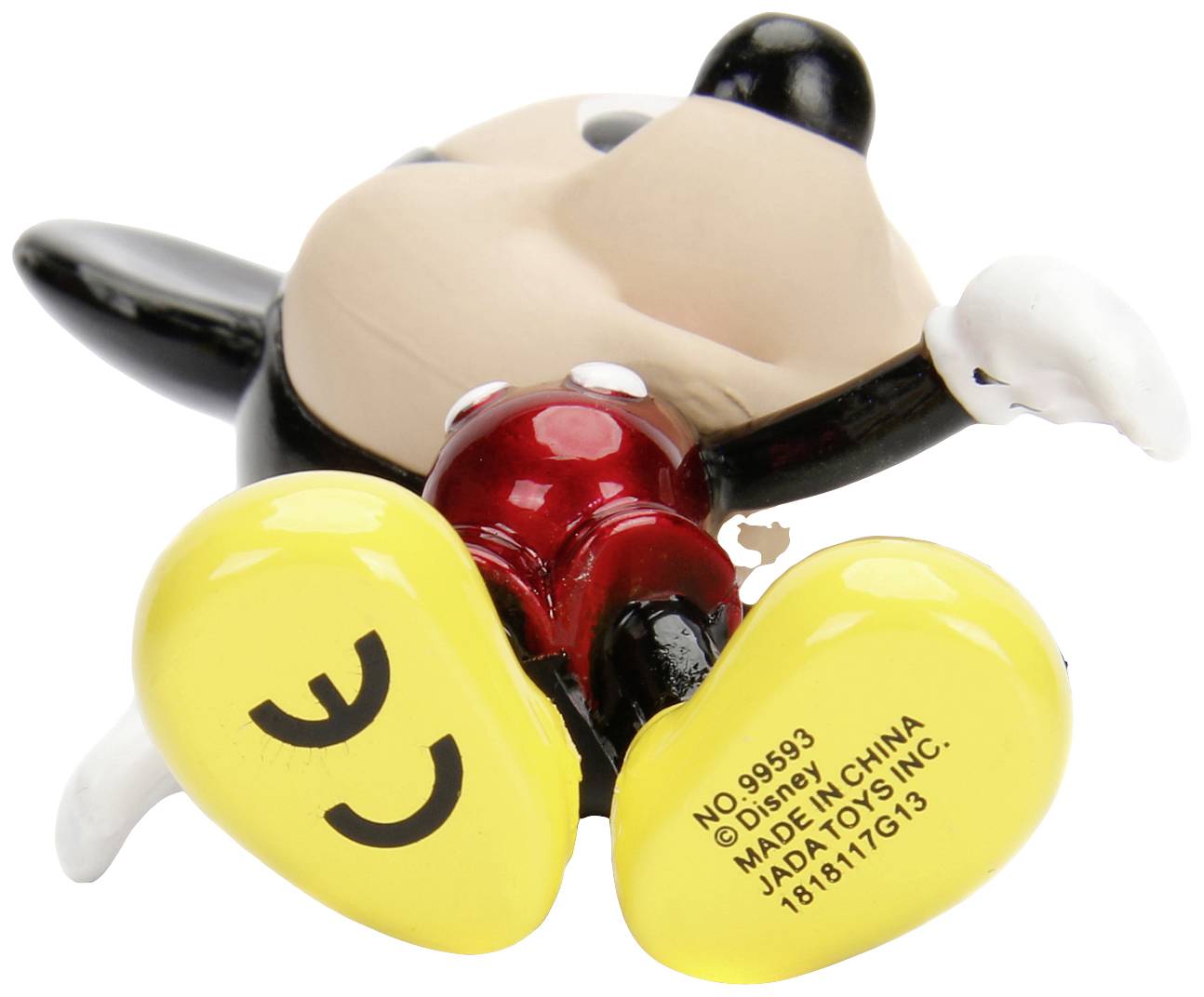 A figure lying on its back. Yellow shoes with a number and 'Made in China'. Face not visible. A toy or collector's figurine.