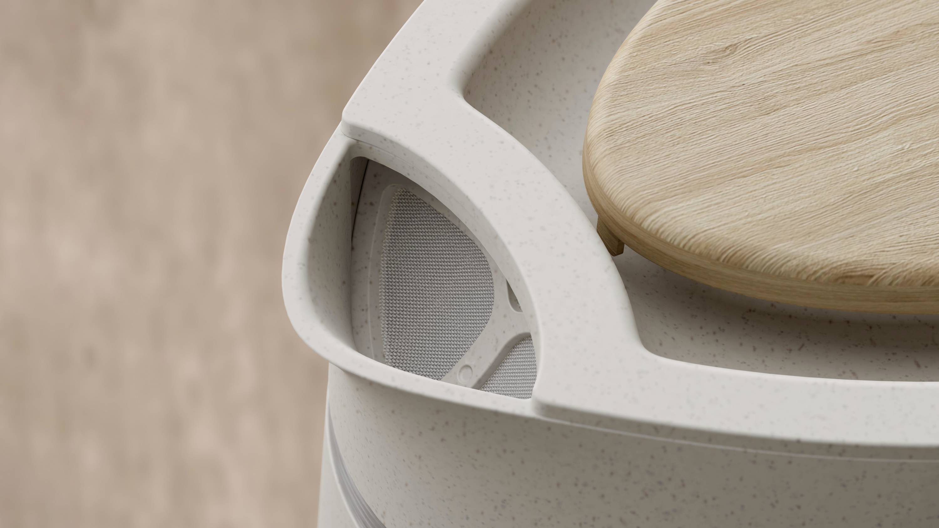 A round speaker with a wooden lid on a table surface, featuring a modern design with neutral colours.
