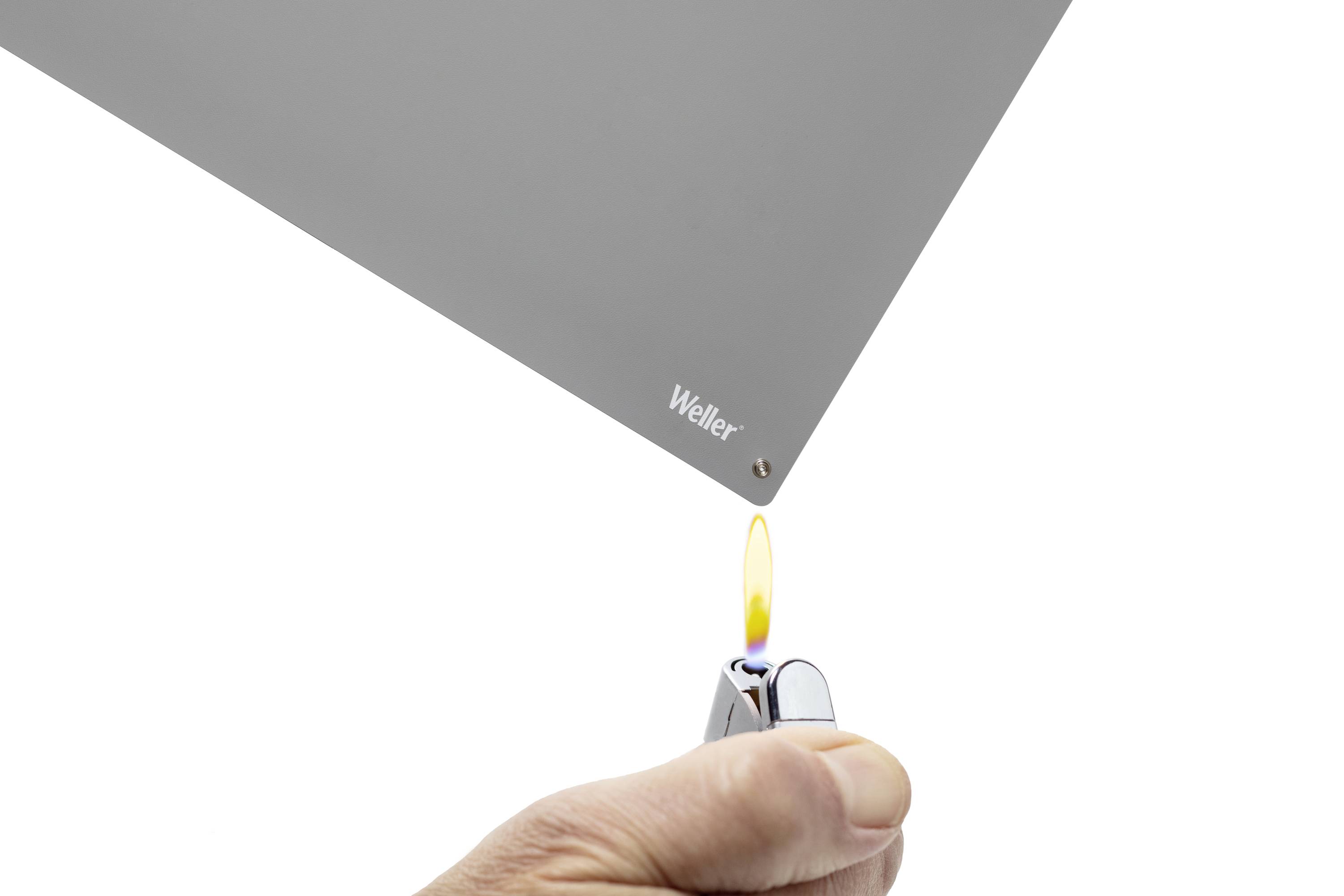 'Weller' brand mark on a grey surface close to an inflamed lighter flame. Test image for material heat resistance.