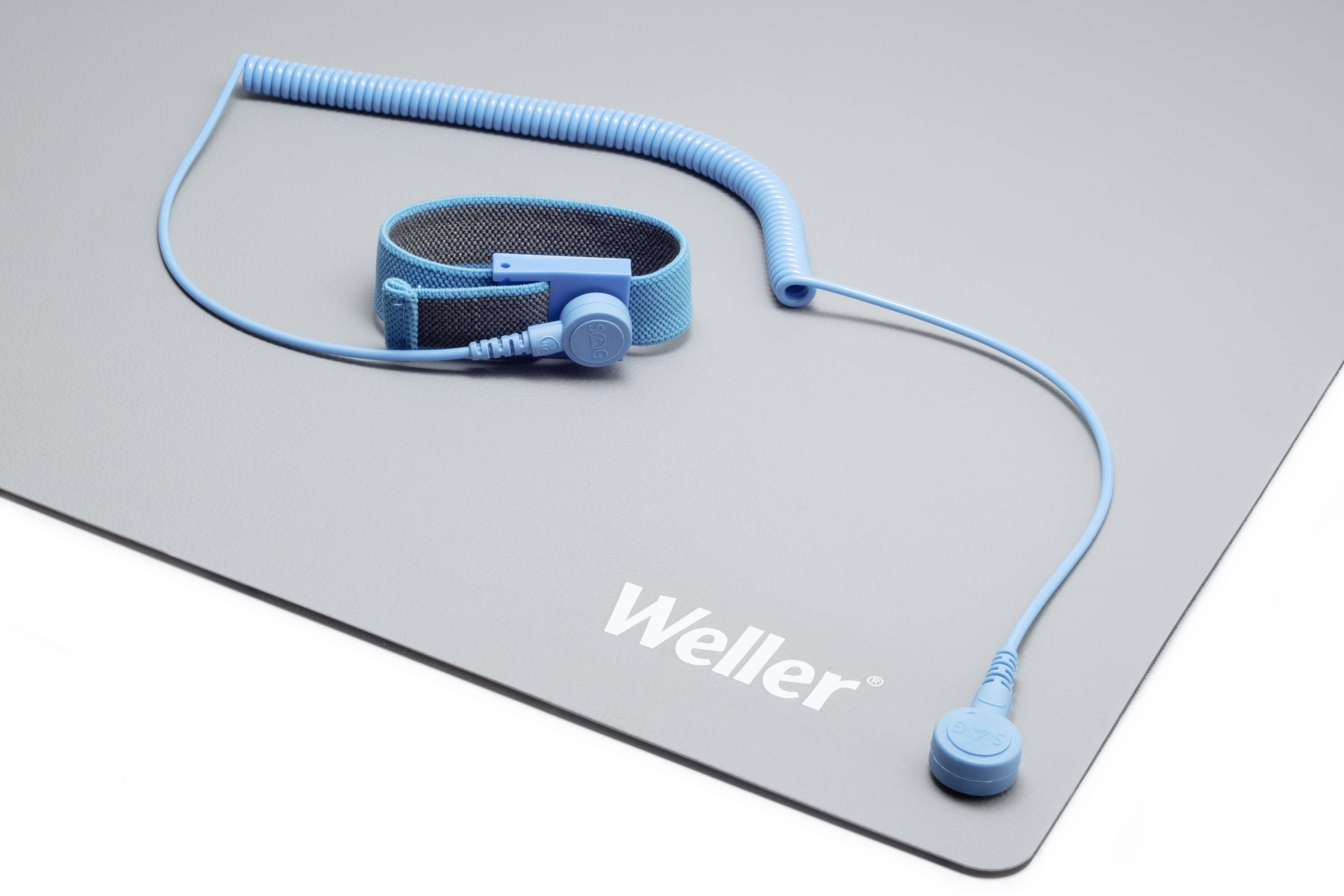 Blue earthing cable and wristband on a grey mat with 'Weller' logo. Used for static discharge protection.