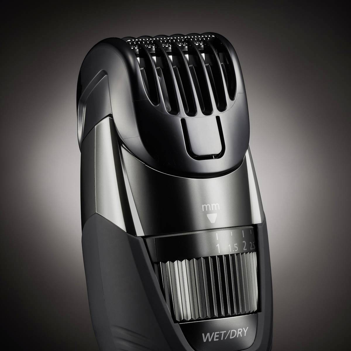 Electric hair clipper in black and silver with adjustable length setting switch and 'Wet/Dry' function. Illuminated background.