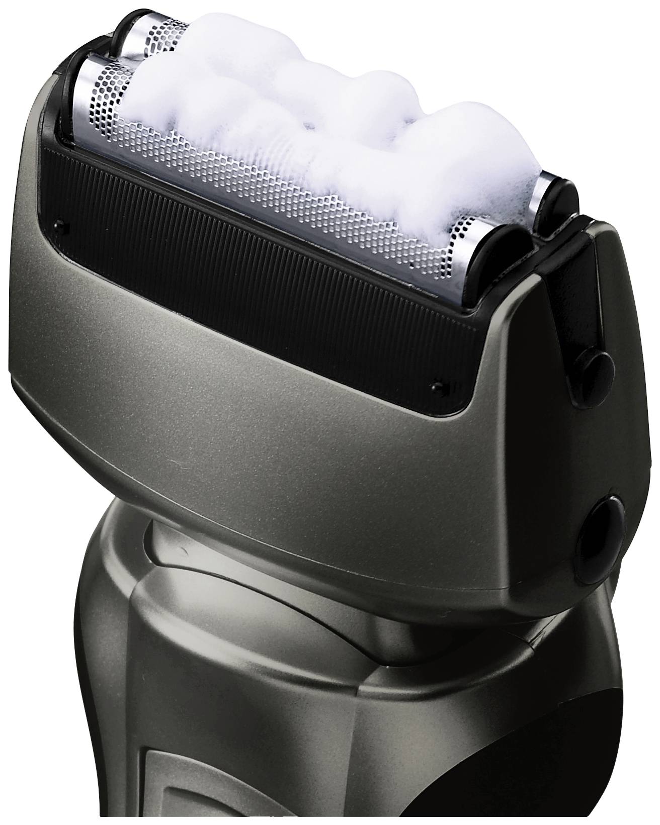Electric razor with foam application on the blades, close-up of the cutting heads in black metal design.