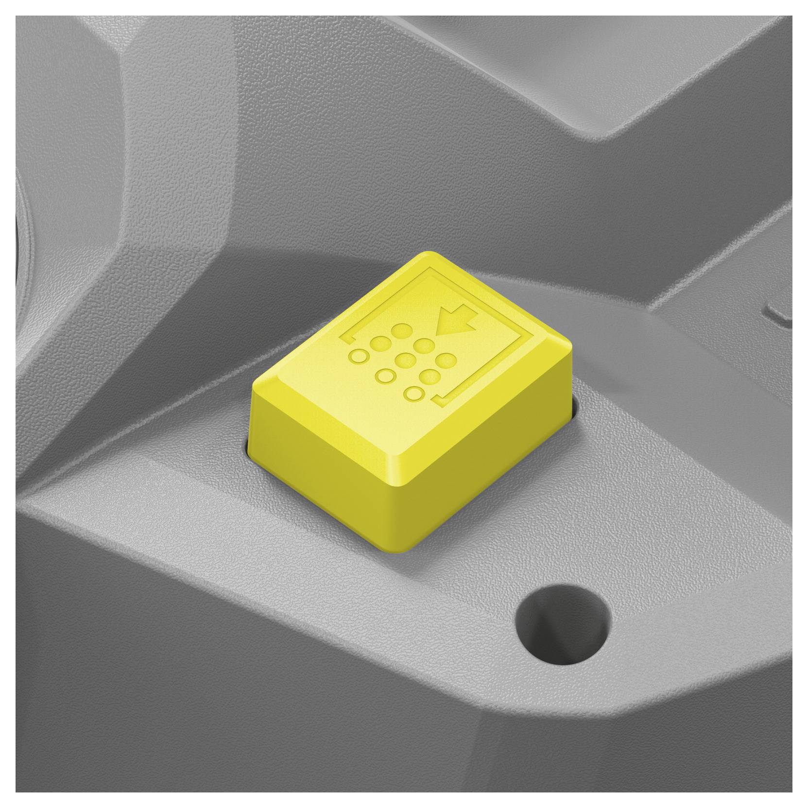 A yellow raised symbol indicating accessibility features, like braille or tactile guidance, on gray equipment surface.