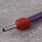A silver metal tube with a red, hexagonal plastic handle and a purple cable on a grey surface.