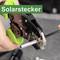 A hand is using a tool to crimp a solar connector. In the background, a blurred table is visible. Text: 'Solar Connector'.