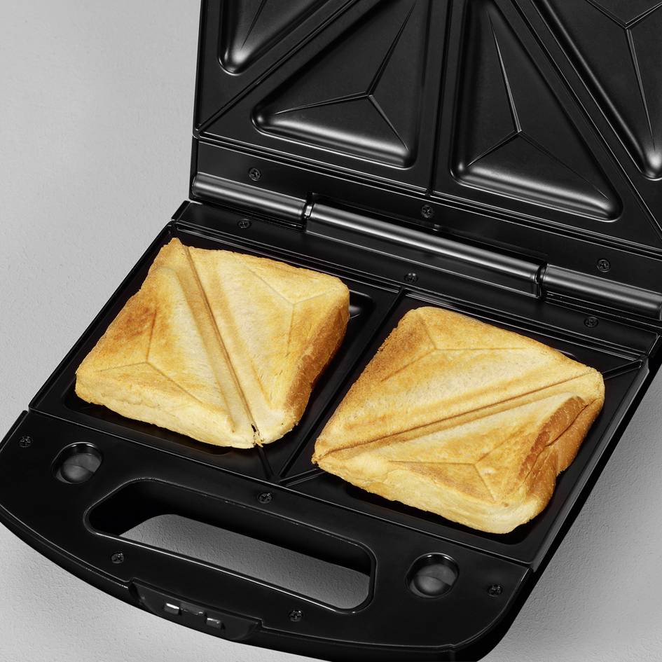 A sandwich maker with two golden-brown toasted sandwiches in a pyramid shape.