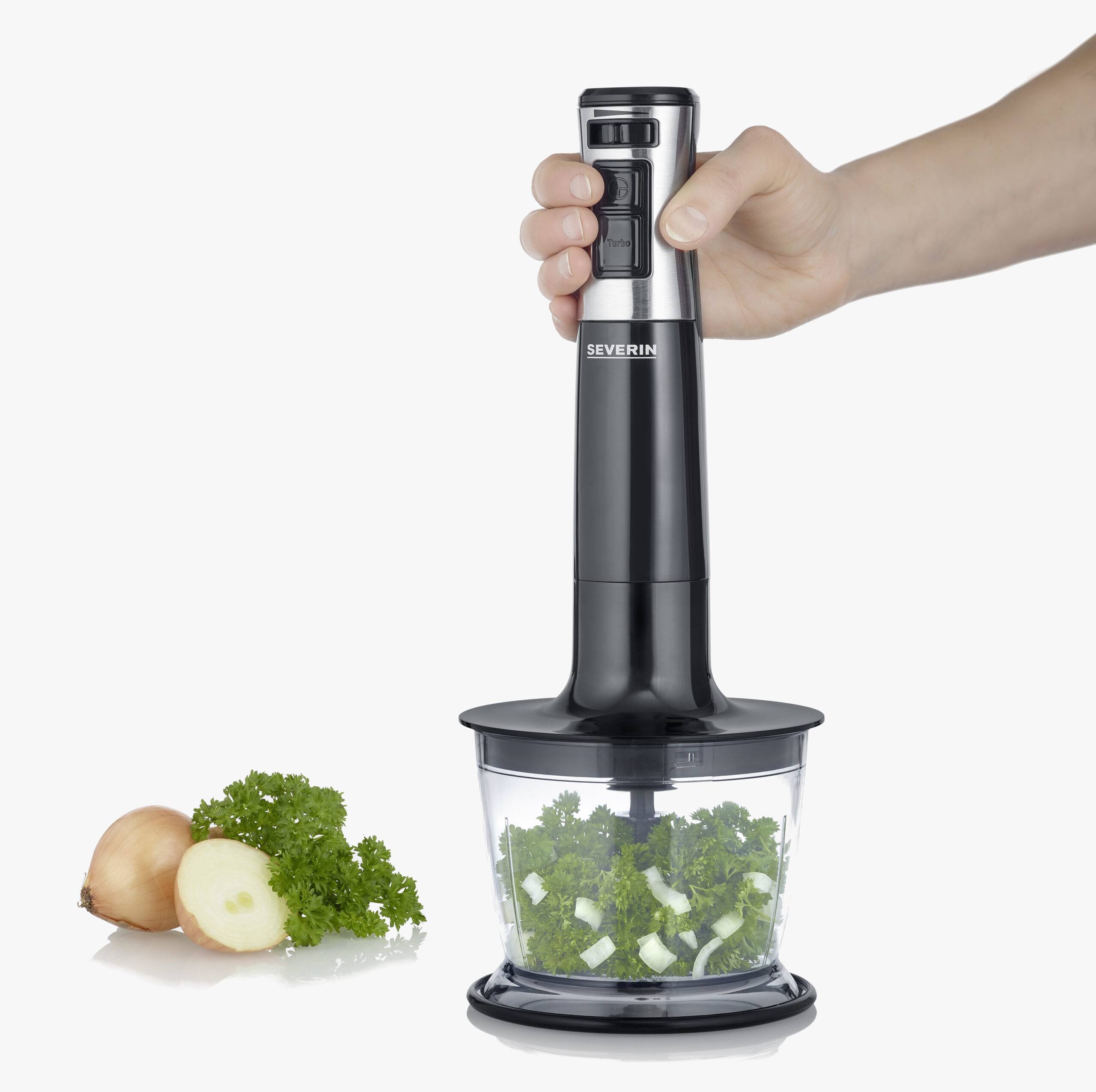 'Hand mixer chops fresh herbs and onions in a transparent container'