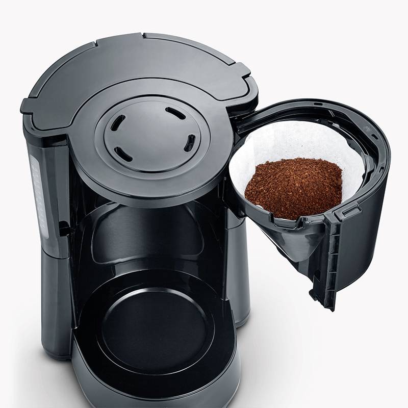 Coffee machine with an open filter holder displaying fresh coffee grounds. Essential for preparing fresh filter coffee.