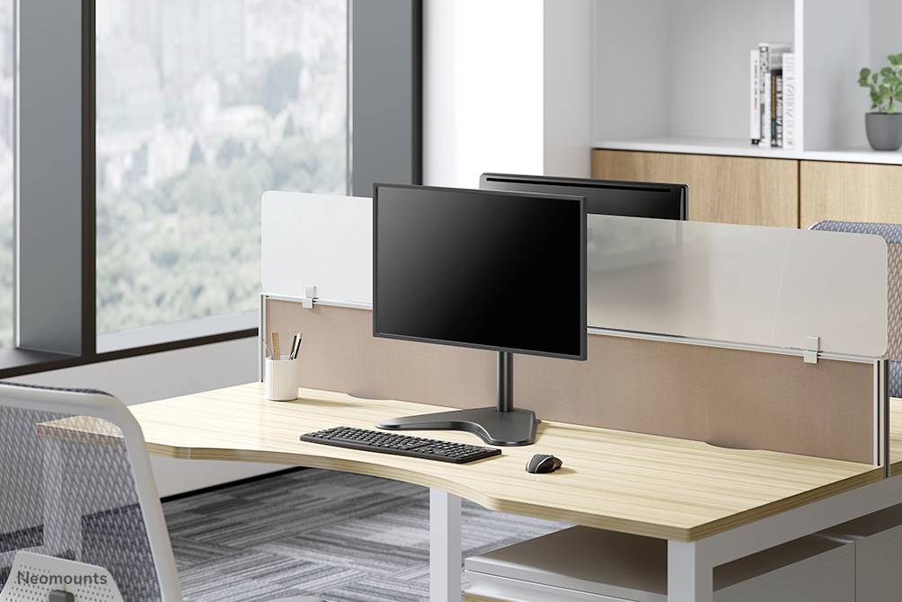 A modern office with two workstations at one desk, each with a monitor, keyboard and mouse. Large windows provide a view.