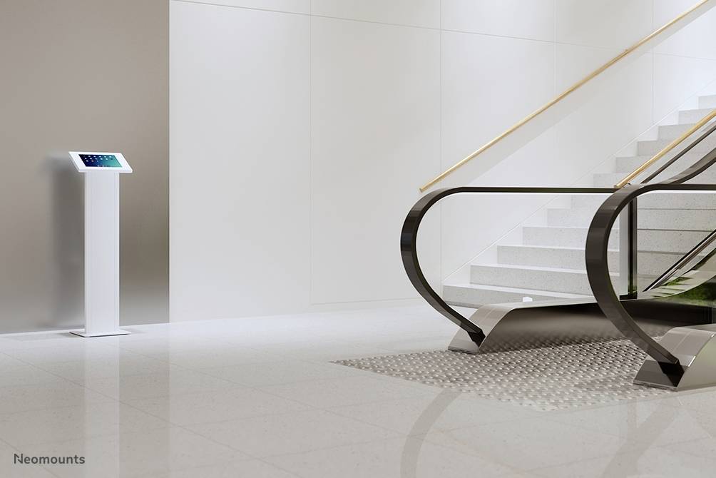 'Lobby with escalator and stairs; information terminal on the left displays screen with digital information.'