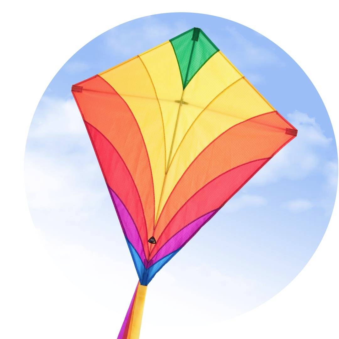 A colourful kite with red, orange, yellow and green segments flies in the blue sky with a few white clouds.