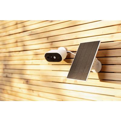 Solar-powered security camera mounted on a wooden facade, surrounded by warm sunlight, symbolising sustainable surveillance.