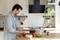 A man is chopping vegetables in a modern kitchen. Bowls of salad ingredients are on the worktop, and kitchen appliances are visible in the background.