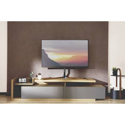 Television on a modern TV stand, displaying a mountain landscape at sunset. Decorative elements such as a clock and plant beside it.