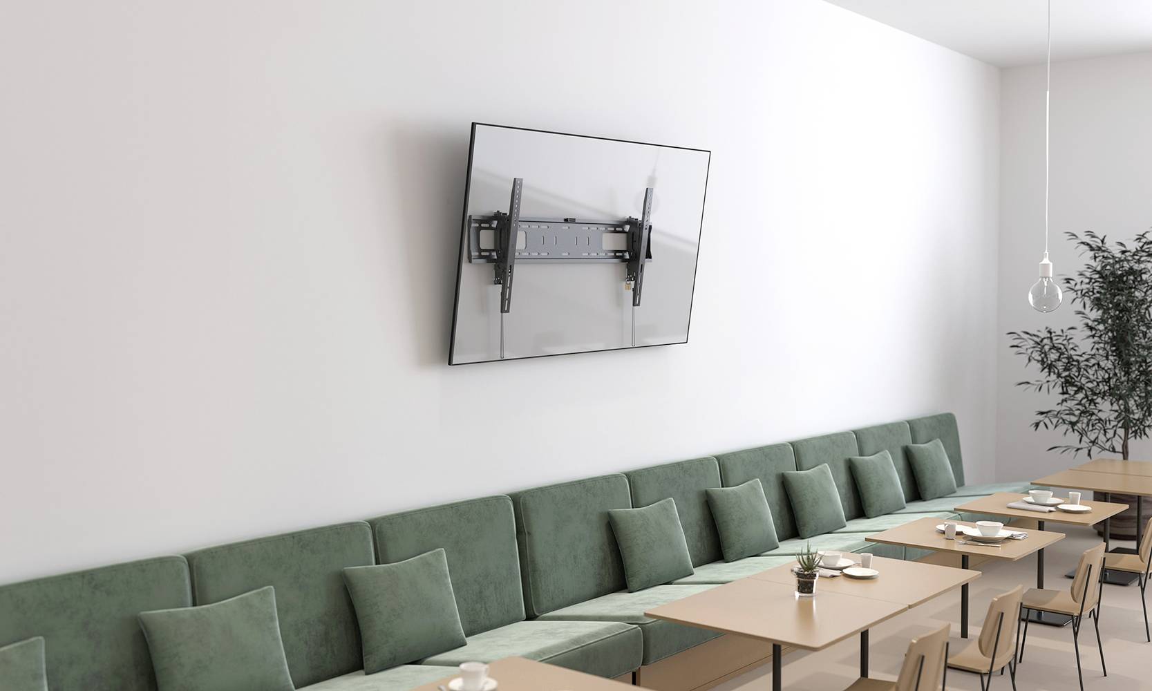 A meeting room with a long green sofa, wooden tables and a large flat-screen monitor mounted on the wall.