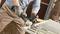 A person is cutting metal rods with an angle grinder. Sparks are flying from the cutting point. They are wearing safety gloves.