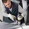 'Person wearing safety glasses grinding metal with an angle grinder in workshop.'