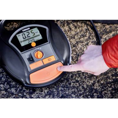 A hand is pressing a button on an OSRAM digital tyre pressure gauge. The screen displays '0.25' bar.