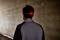 A person in a grey top walks through a dark tunnel. A red light glows at the back of their headband.