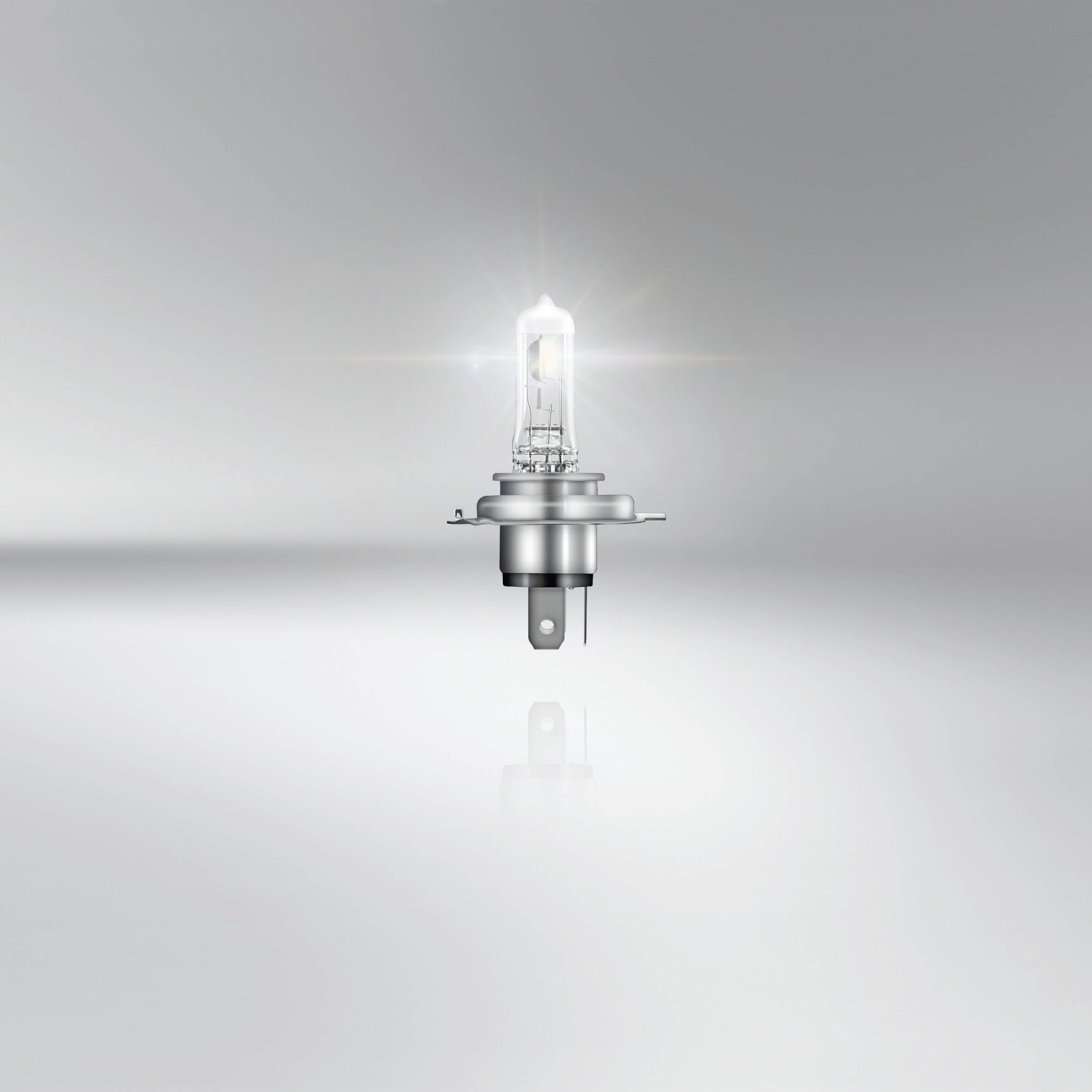 A single, illuminated light bulb against a grey background.