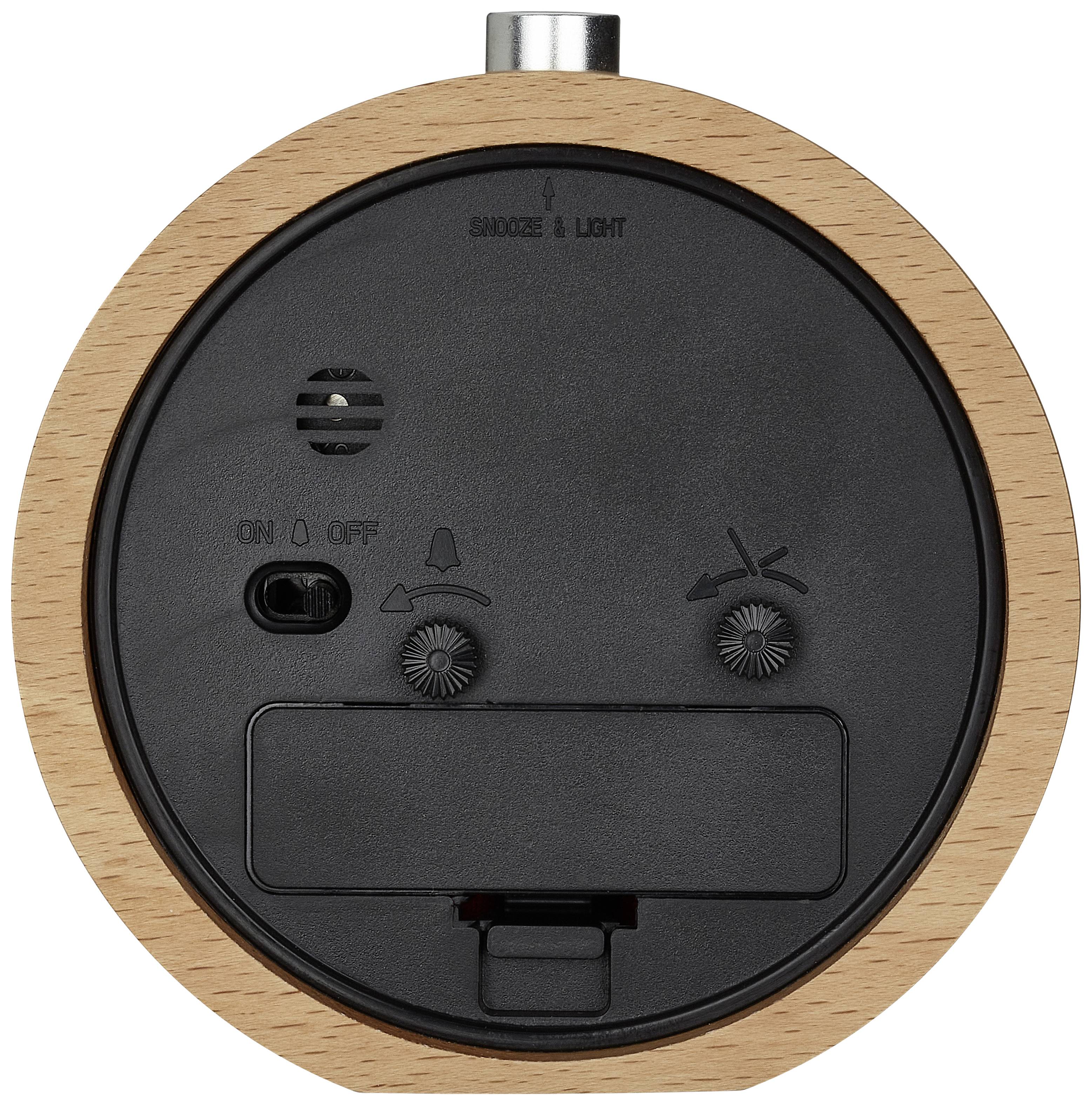 Back of a round alarm clock with a wooden frame, showing buttons for 'Snooze & Light', speakers, ON/OFF switch, and battery compartment.
